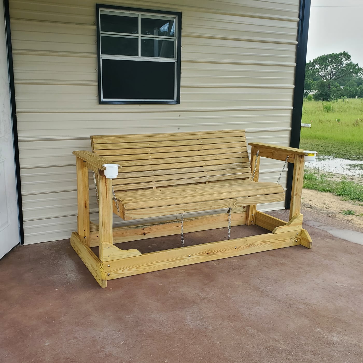 Finished wooden glider bench with stainless chain suspension and pressure-treated lumber construction